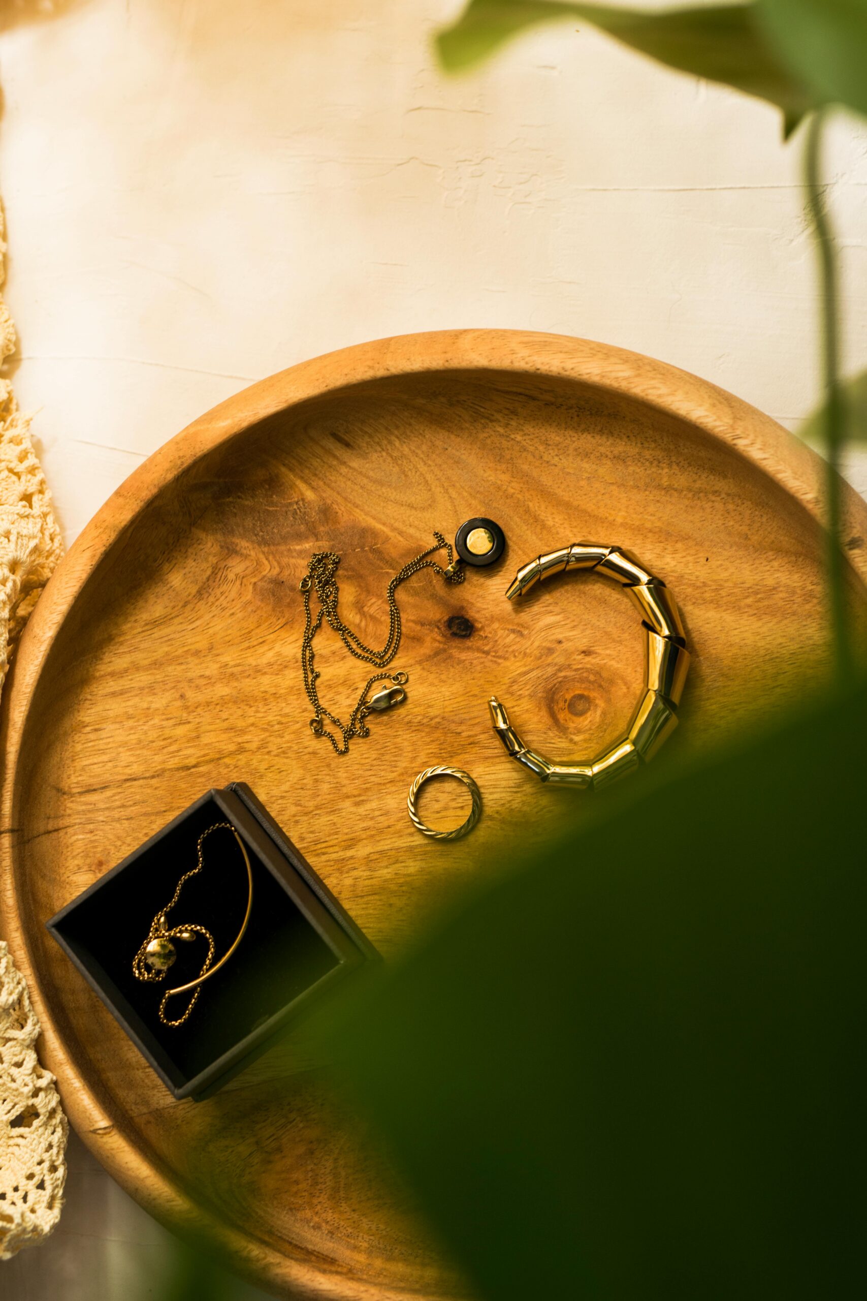 High-quality flat lay of various jewelry pieces on a wooden tray with natural light.